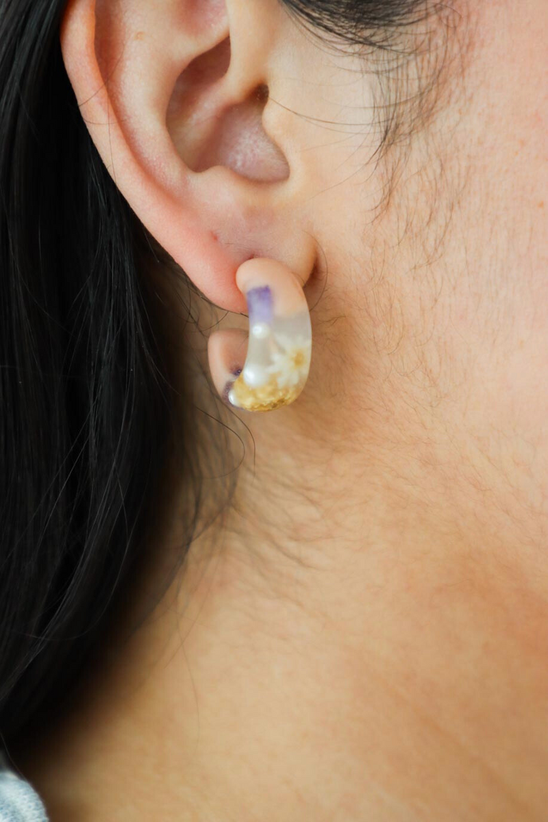 girl wearing multicolored resin earrings