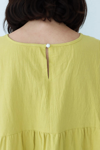 button detailing on the back of a yellow flowy tank top