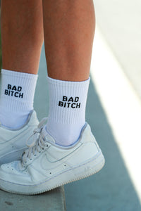 white crewnecks embroidered with "bad bitch" in black text