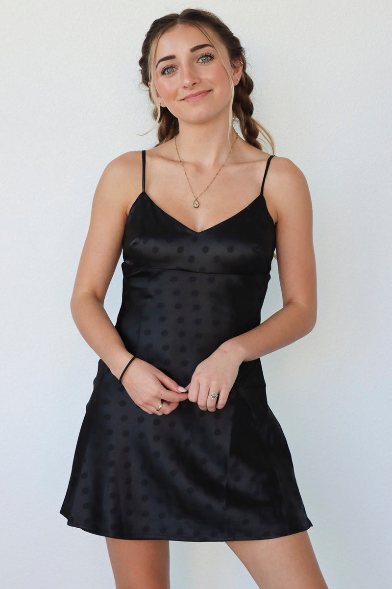 girl wearing black slip dress with polka dot detail