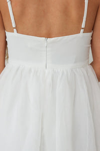 close up of zipper detailing on the back of a short white dress