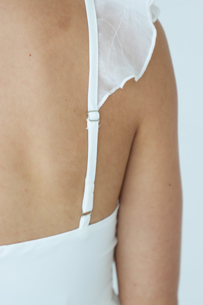 close up of adjustable straps on a short white dress