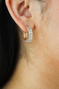 girl wearing small, gold rhinestone earrings