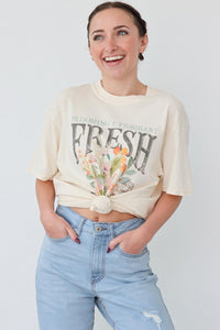 girl wearing cream "fresh flowers" graphic t-shirt