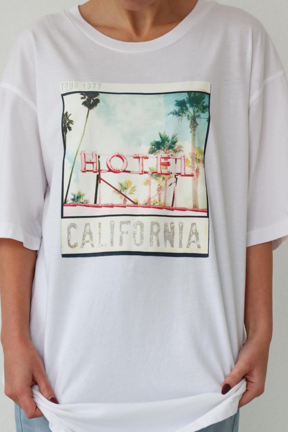 girl wearing white oversized "Hotel California" graphic t-shirt