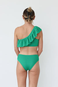 girl wearing one shoulder green ruffled bikini