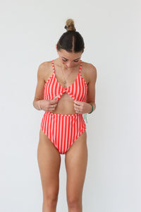 girl wearing red striped one piece swimsuit