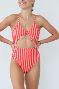 girl wearing red striped one piece swimsuit