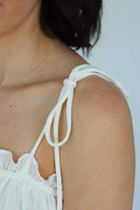 close up of adjustable tie straps of a white tank top