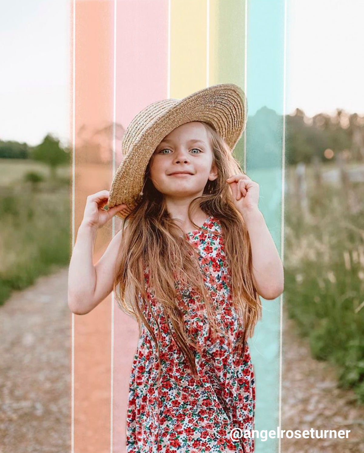 young girl in a field with rainbow stripes behind her