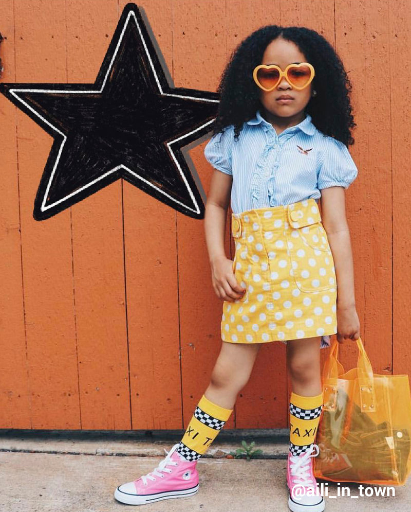 young girl posing for a photo with a black draw star behind her