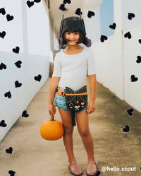 girl in a halloween costume with black drawn hearts around her