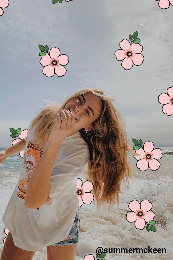 girl on beach with pink hawaiian flowers drawn on the photo