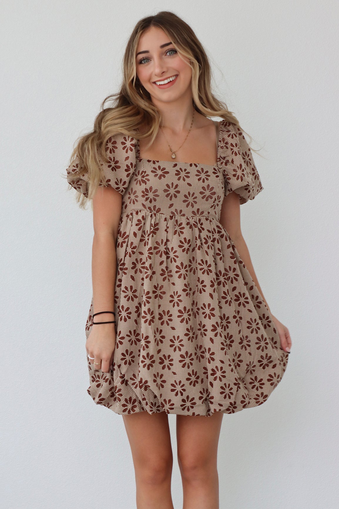 girl wearing brown babydoll. dress with dark brown flowers