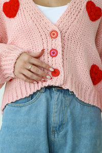 Pink knitted sweater with knitted red hearts