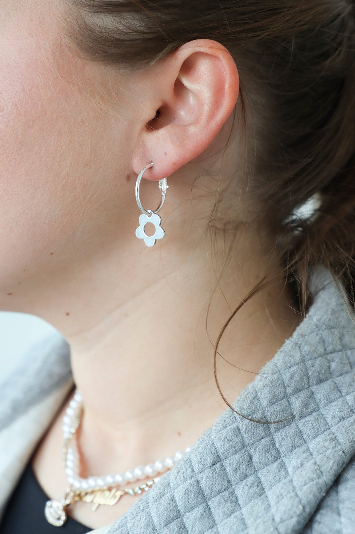 girl wearing silver flower hoop earrings