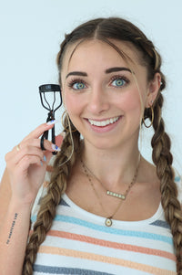 girl holding eyelash curler