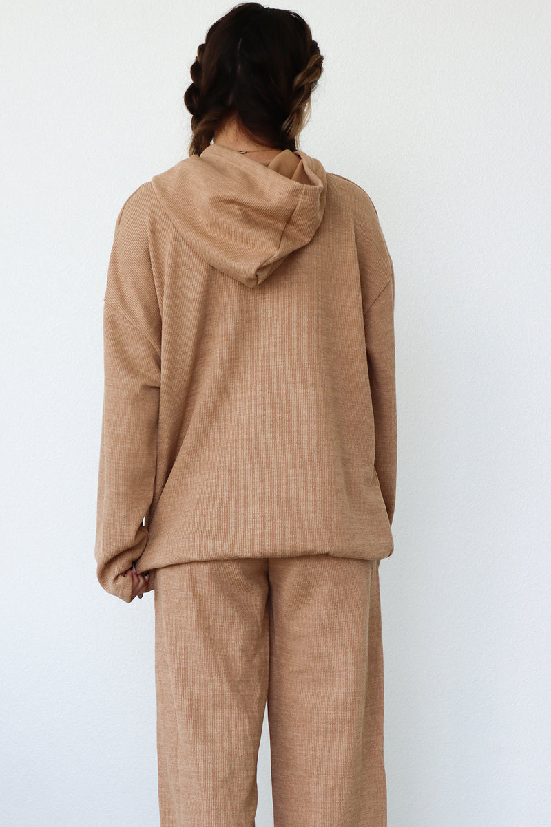 back of girl wearing tan lounge suit with functional hood