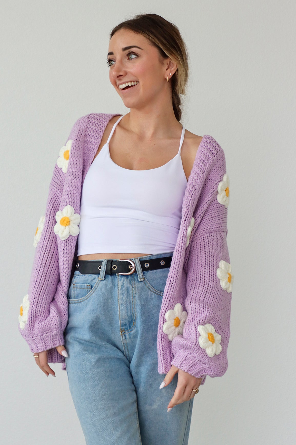 girl wearing a purple knit cardigan with daisies
