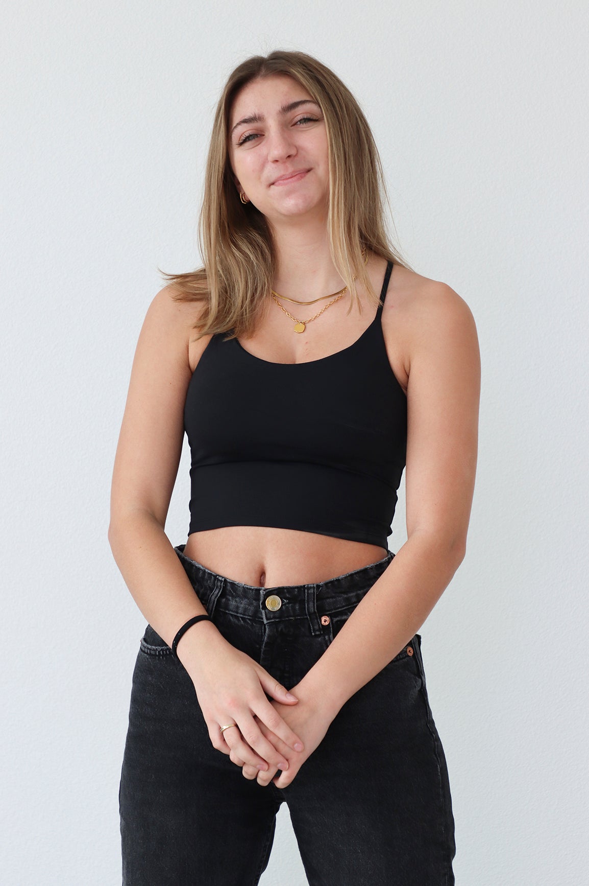 girl wearing black athletic tank top with thin straps and built in padded bra