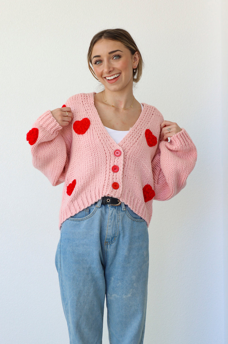 Pink knitted sweater with knitted red hearts