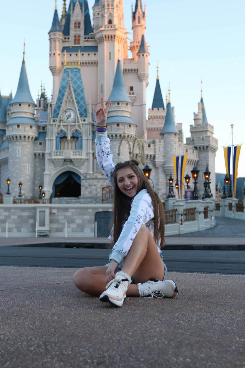 Bright preset before photo of a girl sitting in front of a Disney castle