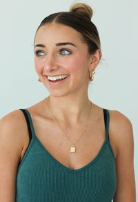 girl wearing gold book necklace