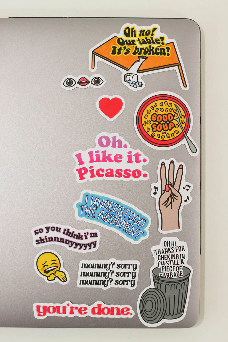stickers on a laptop- oh no our table is broken, eye lips eye, heart emoji, alphabet soup that says "good soup", "oh. I like it. Picasso.", 3 Finger Taps to musica, "I understood the assignment", "so you think I'm skinnnnyyyy", ice on my veins emoji, "mommy sorry" x 3 times, "oh hi thanks for checkin in. I'm still a piece of garbage" in a trash can, "you're done"